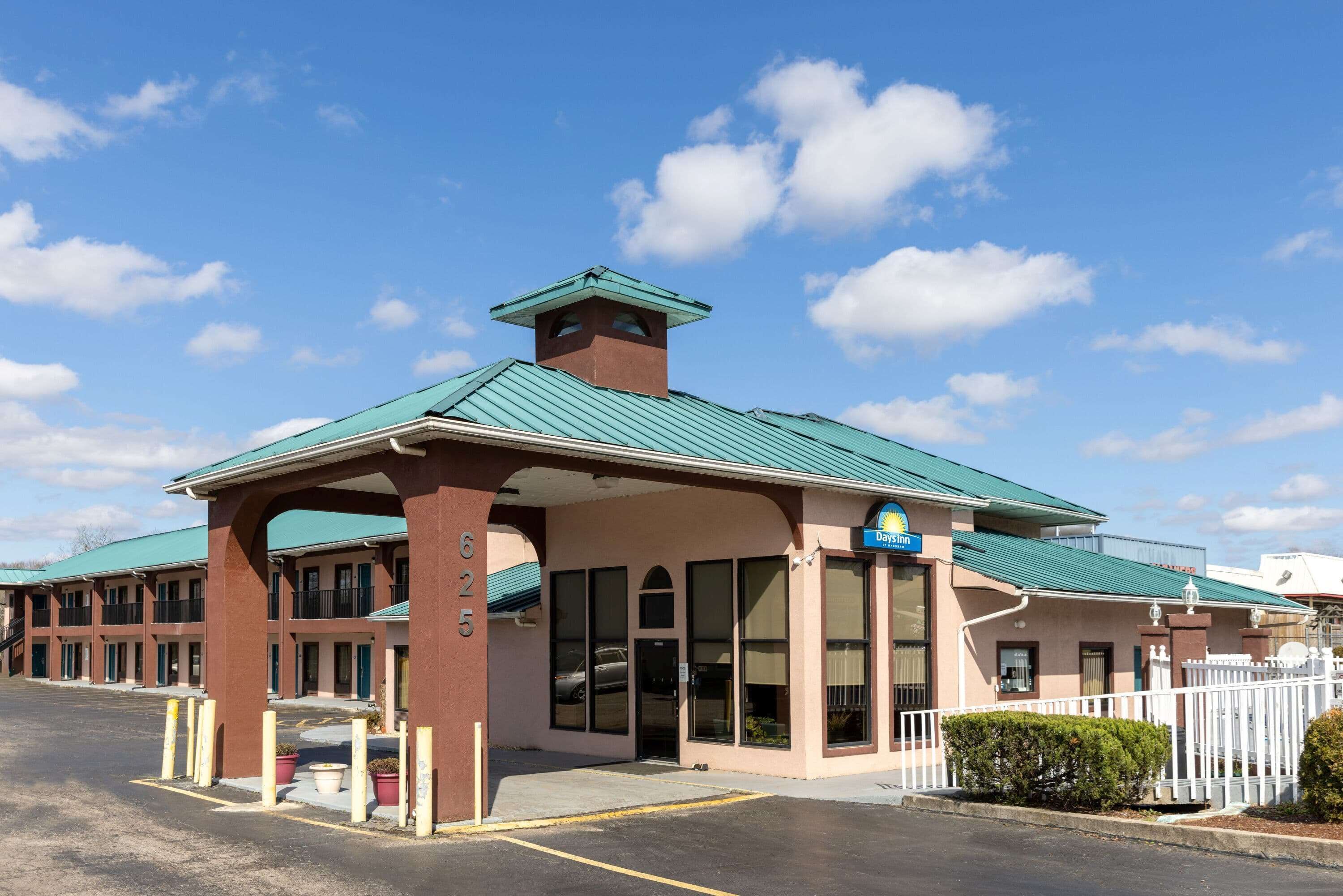 A motel with a green roof, a covered entrance, and a sign indicating it is a Days Inn.