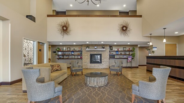 A spacious lobby with a central seating area, a fireplace, and a reception desk. - Best Western Plus Vintage Valley Inn (Zillah)