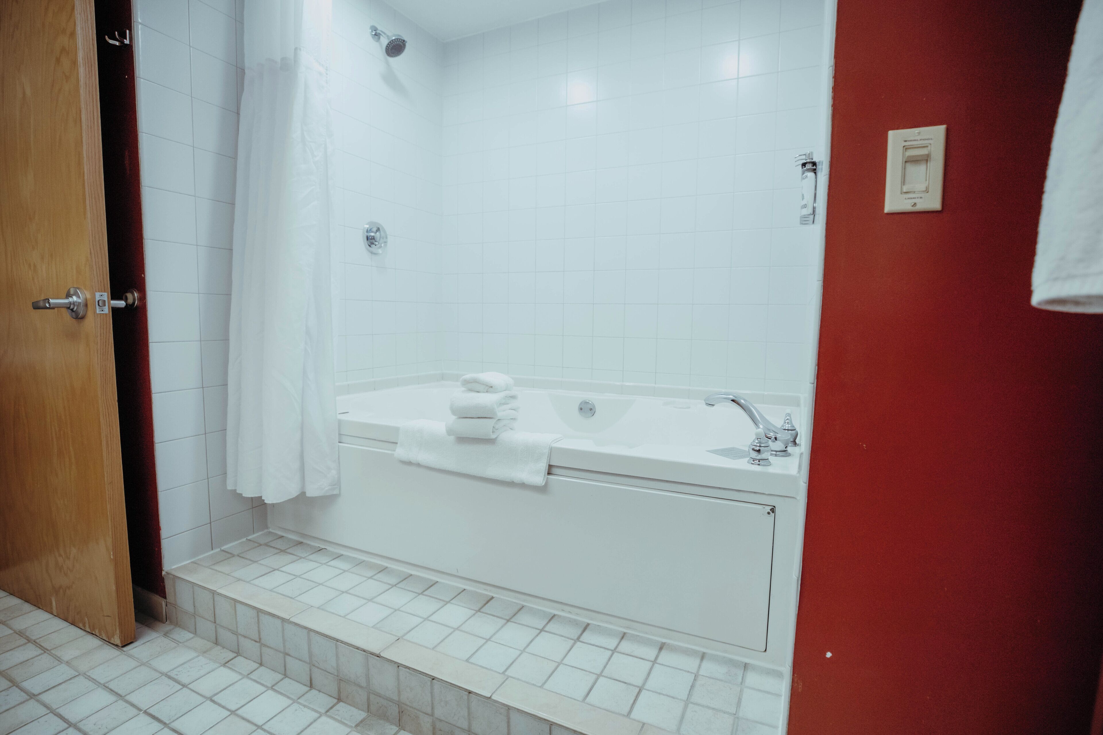 A bathroom with a white bathtub, a sink, and a shower.