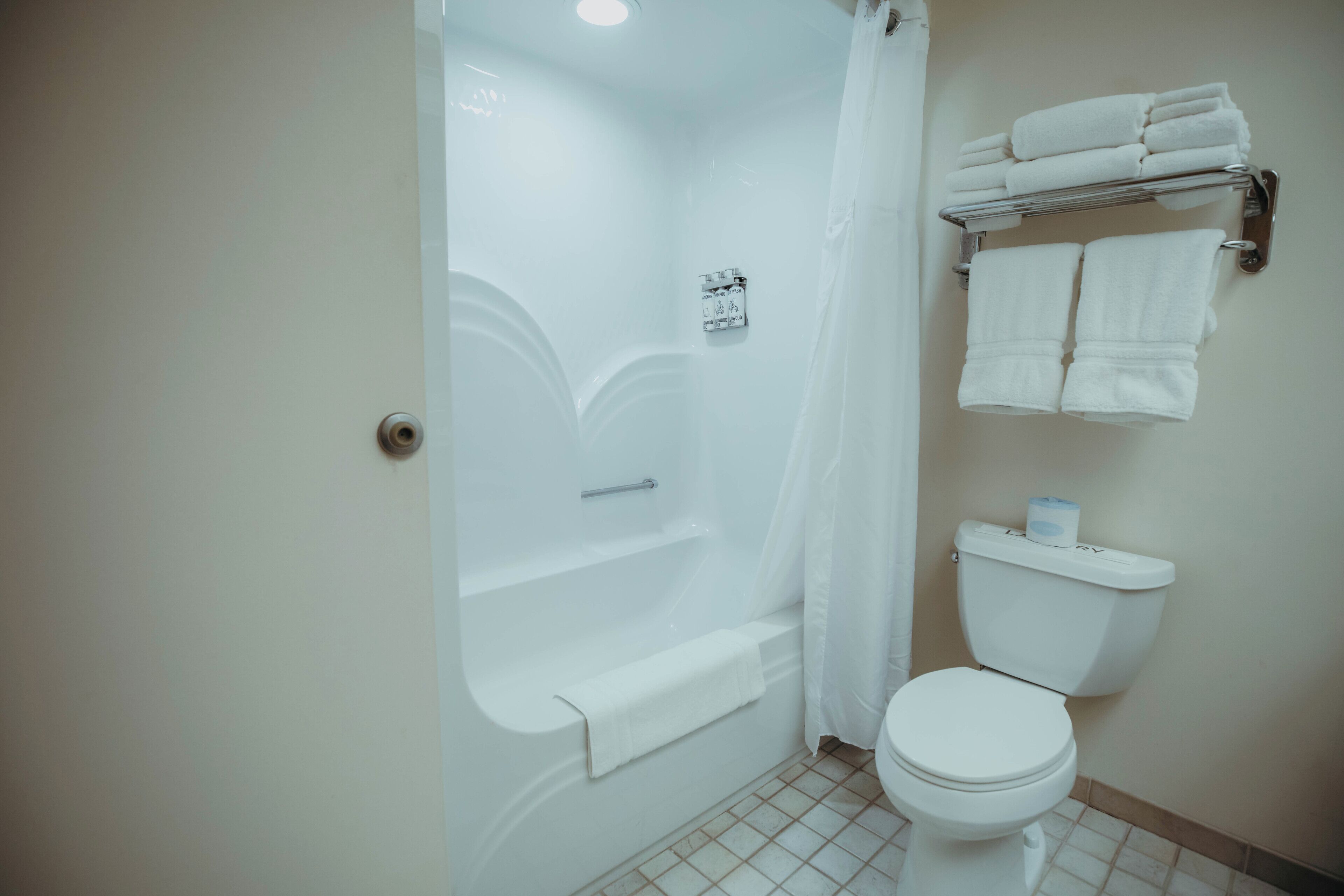 A bathroom with a bathtub, toilet, and towel rack.