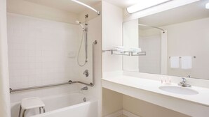 A modern bathroom with a white bathtub, a shower, a sink, and a large mirror. - Super 8 by Wyndham Lavonia (Lavonia)