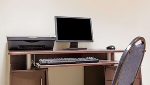 A computer desk with a monitor, keyboard, and printer. - Super 8 by Wyndham Lavonia (Lavonia)