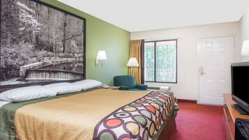 A hotel room with a large bed, a television, a desk, and a window with curtains.