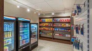 A grocery store with refrigerated beverage coolers, snack shelves, and a wall-mounted display of bottled water. - Holiday Inn Express Vermilion by IHG (Vermilion)