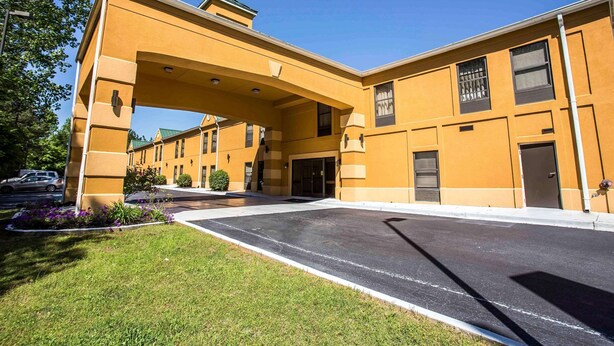 A multi-story hotel with a yellow facade, large windows, and a covered entrance.