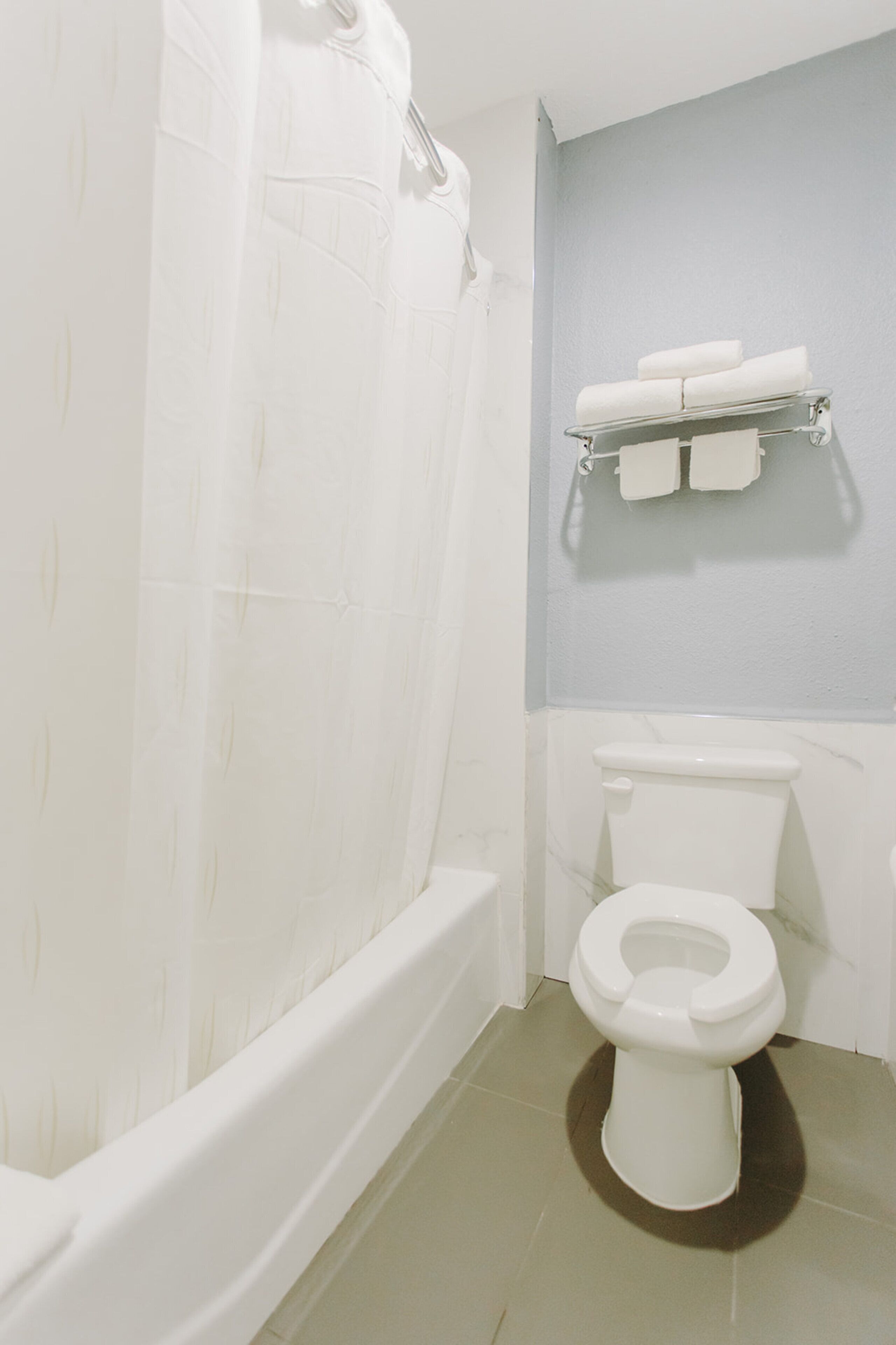 A bathroom with a bathtub, toilet, and towel rack.