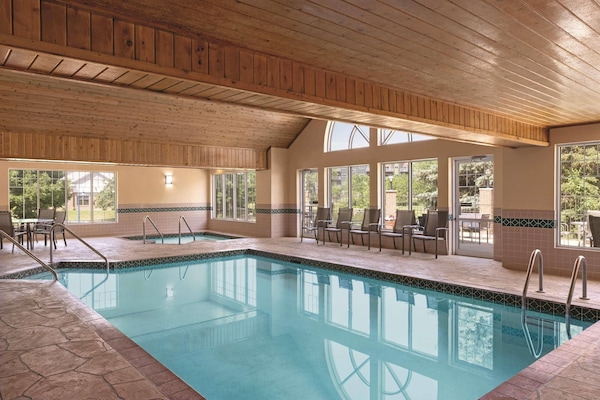 Una piscina techada, sillones reclinables de piscina