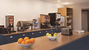 A modern kitchen with a built-in coffee station, a toaster, and a bowl of fruit on the counter. - Country Inn & Suites by Radisson, Madison, WI (Madison)