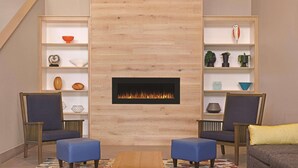 A living room with a fireplace, two armchairs, a sofa, and a coffee table. - Country Inn & Suites by Radisson, Madison, WI (Madison)