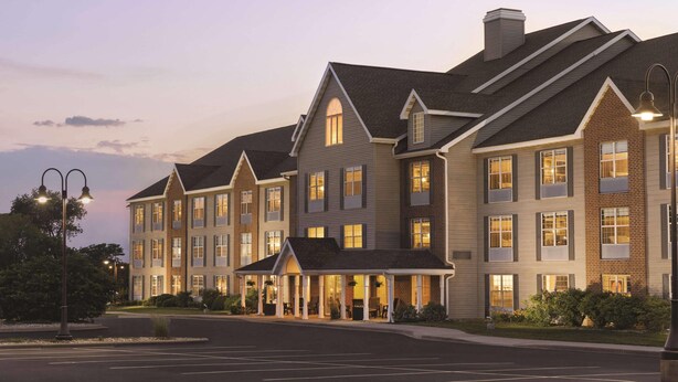 A multi-story hotel with a central courtyard, large windows, and a brick facade. - Country Inn & Suites by Radisson, Madison, WI (Madison)