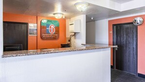 A reception area with a counter, a sign for Motel 6, and a door with a number. - Motel 6 Moriarty, NM (Moriarty)