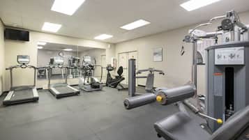 Uma academia com esteiras, máquinas de peso e equipamentos de ginástica.
