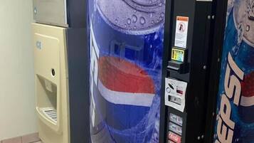 Una máquina expendedora con el logotipo de Pepsi, un dispensador de agua y un refrigerador.