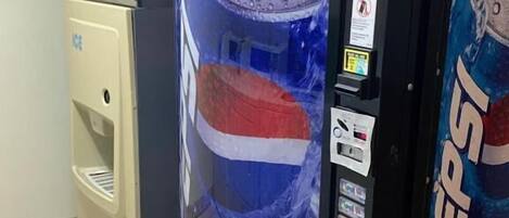A vending machine with a Pepsi logo, a water dispenser, and a refrigerator.