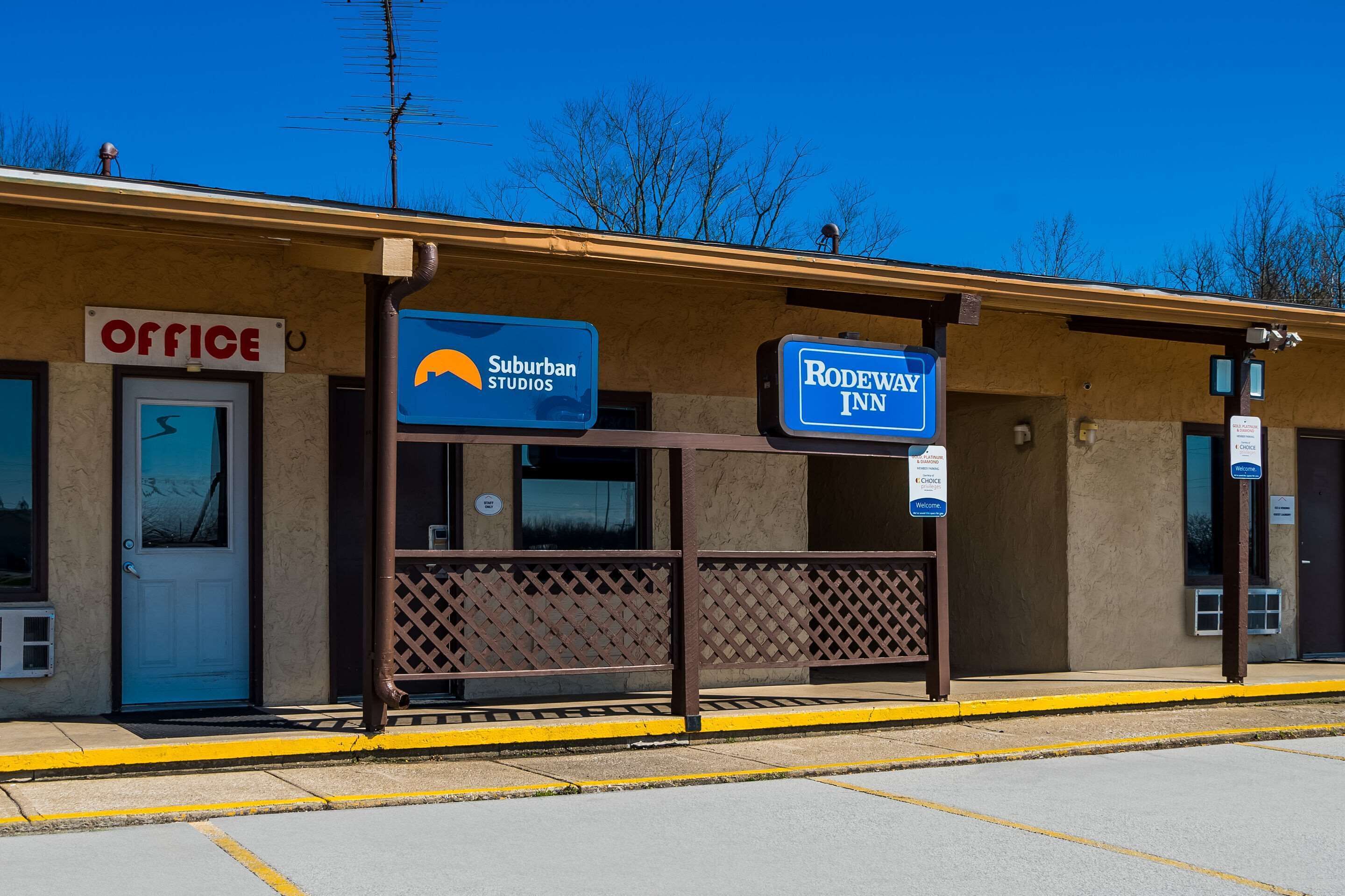 Un edificio con letreros que indican 'Office', 'Suburban Studios' y 'Rodeway Inn'.