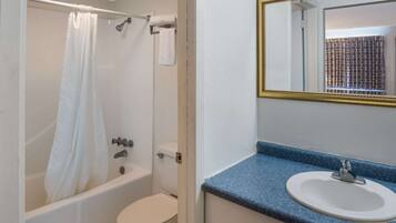 Een badkamer met een bad, toilet en wastafel.