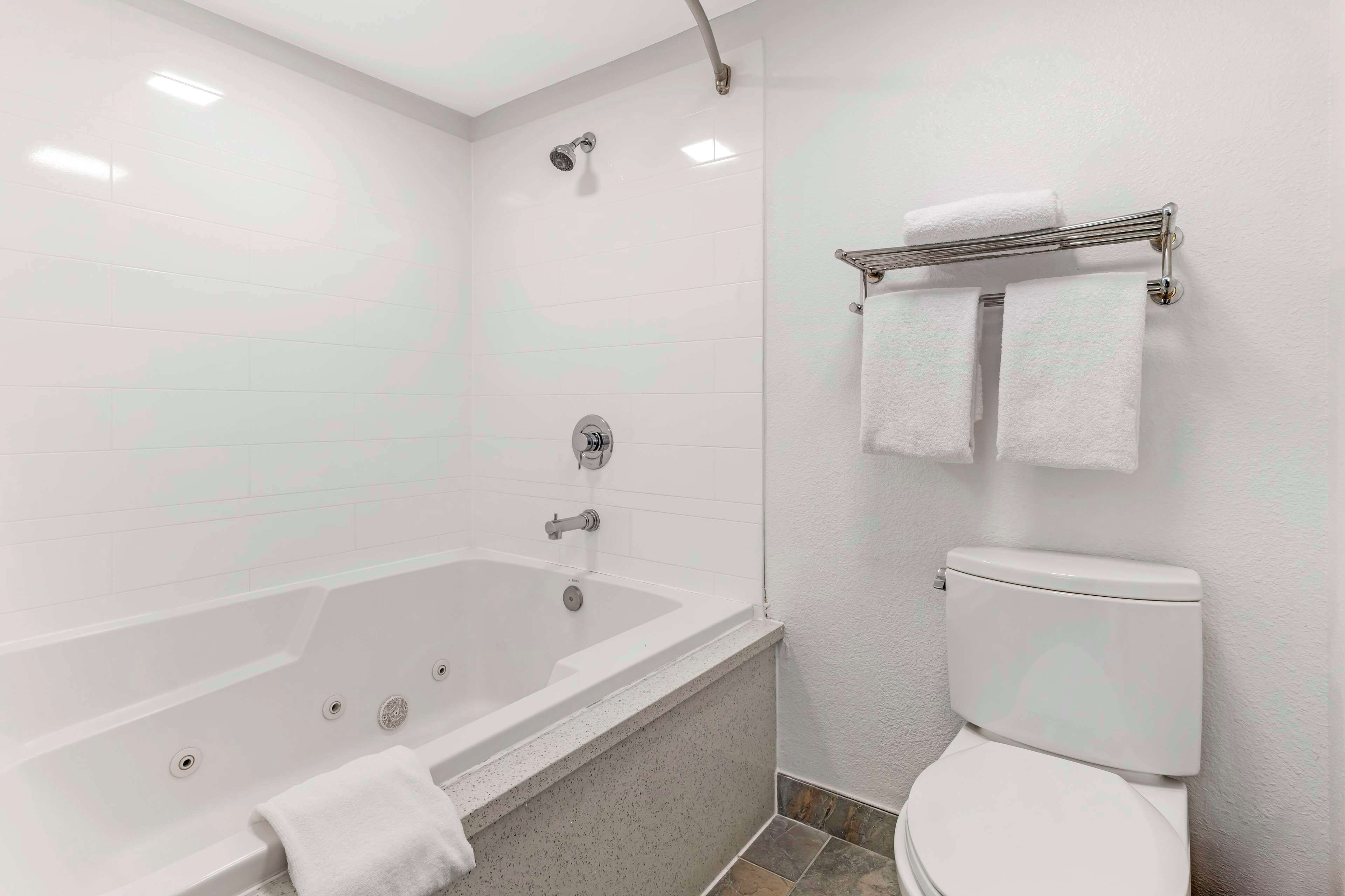 A bathroom with a bathtub, shower, and toilet.