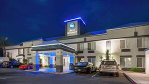 Um hotel Best Western com design moderno, apresentando uma placa grande, entrada coberta e vários carros estacionados.