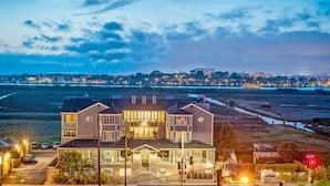 A two-story building with a balcony, located near a coastline with a view of the ocean and city lights in the background. - Inn at Playa del Rey (Playa Del Rey)