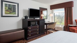 Ein Hotelzimmer mit Bett, Schreibtisch mit Computer, Fernseher, Mikrowelle und einer Sitzecke.