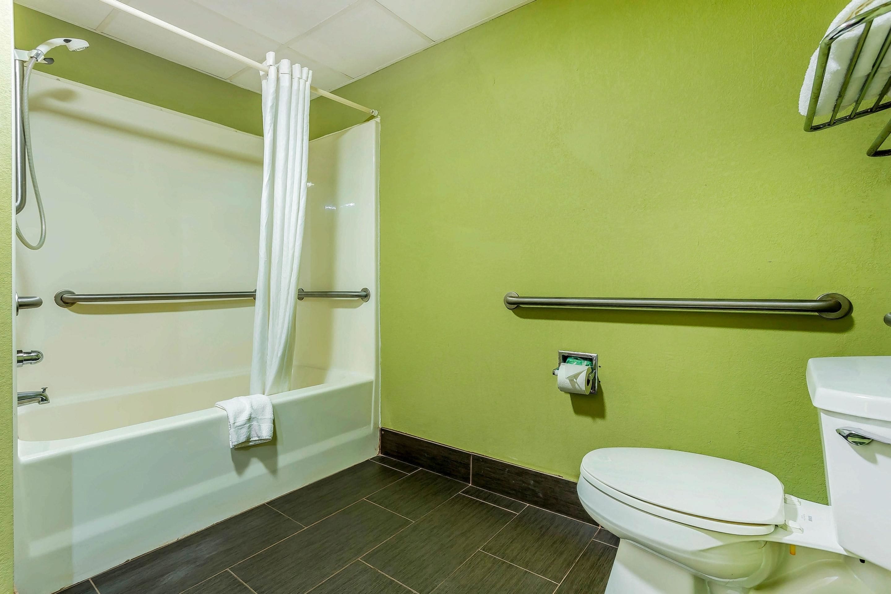 A bathroom with a bathtub, toilet, and a shower area.