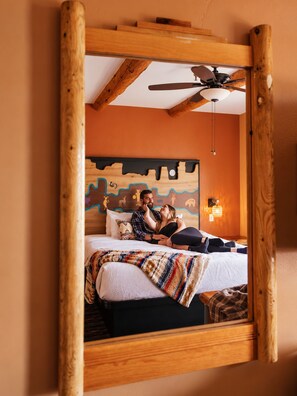A bedroom with a bed, a ceiling fan, and a wall with a mural. - Southwest Inn at Sedona (Sedona)