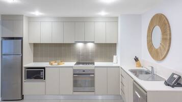A modern kitchen with stainless steel appliances, a built-in oven, and a microwave.