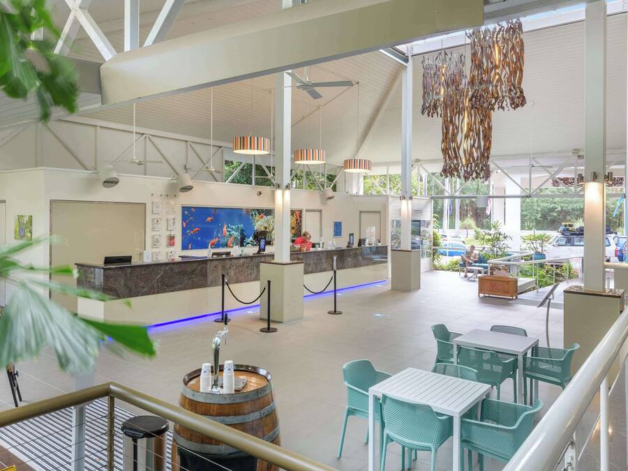 A spacious lobby with a reception desk, seating area, and a large aquarium.