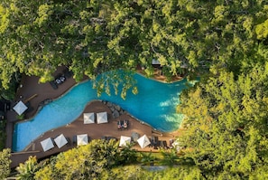 Una piscina al aire libre, sombrillas, sillones reclinables de piscina