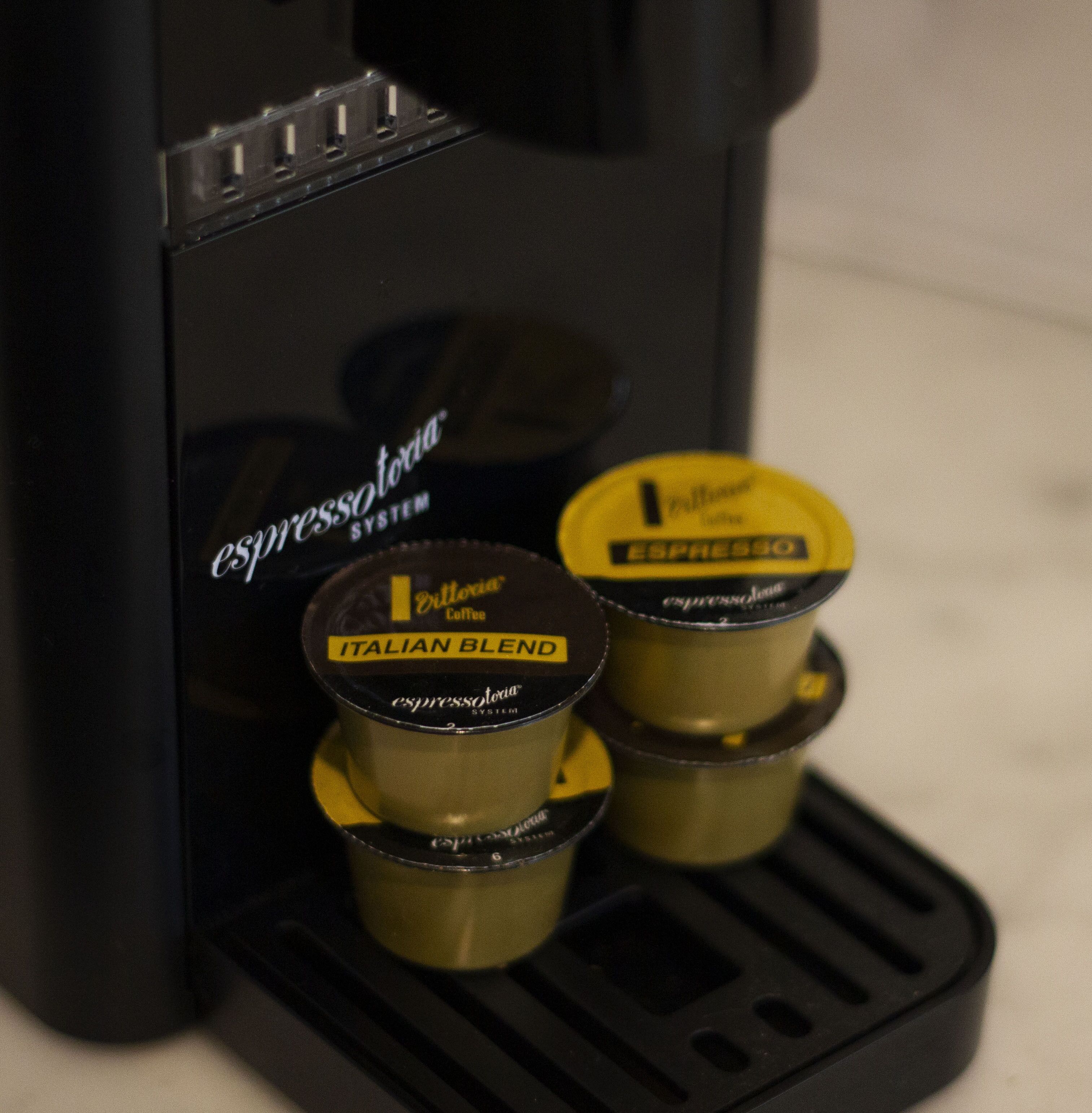 Una cafetera con dos cápsulas de café, una etiquetada como 'Espresso' y otra como 'Mezcla Italiana'.