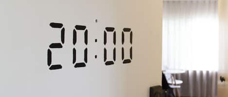 A digital clock displaying 20:00 on a white wall.