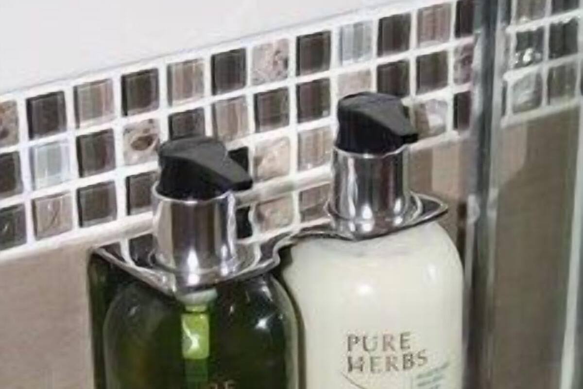 Two bathroom dispensers, one green and one white, labeled 'PURE HERBS.'