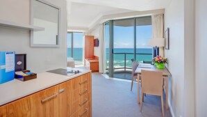 A modern hotel room with a balcony, a dining area, and a view of the ocean. - Mantra Legends Hotel (Surfers Paradise)