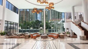 A spacious lobby with a central seating area, large windows, and a staircase. - Mantra Legends Hotel (Surfers Paradise)
