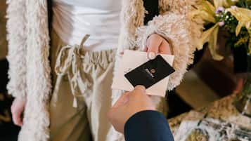A person holding a card and a booklet at a counter.