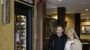 A man and woman walking towards a door labeled "Il Caminito" with a black mat reading "EXECUTIVE AT WHISTLER VILLAGE" in front. - Executive - The Inn at Whistler Village (Whistler)