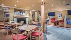 Un vaste espace intérieur aménagé avec différents types de sièges, notamment des tables et des chaises, et doté d’un pilier central.