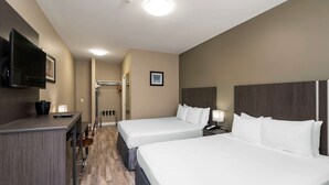 A hotel room with two beds, a TV, a desk with a chair, and a mirror. - Econo Lodge (Prince George)
