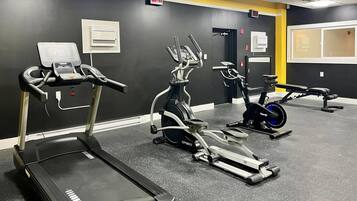 A gym with treadmills, elliptical machines, and a stationary bike.