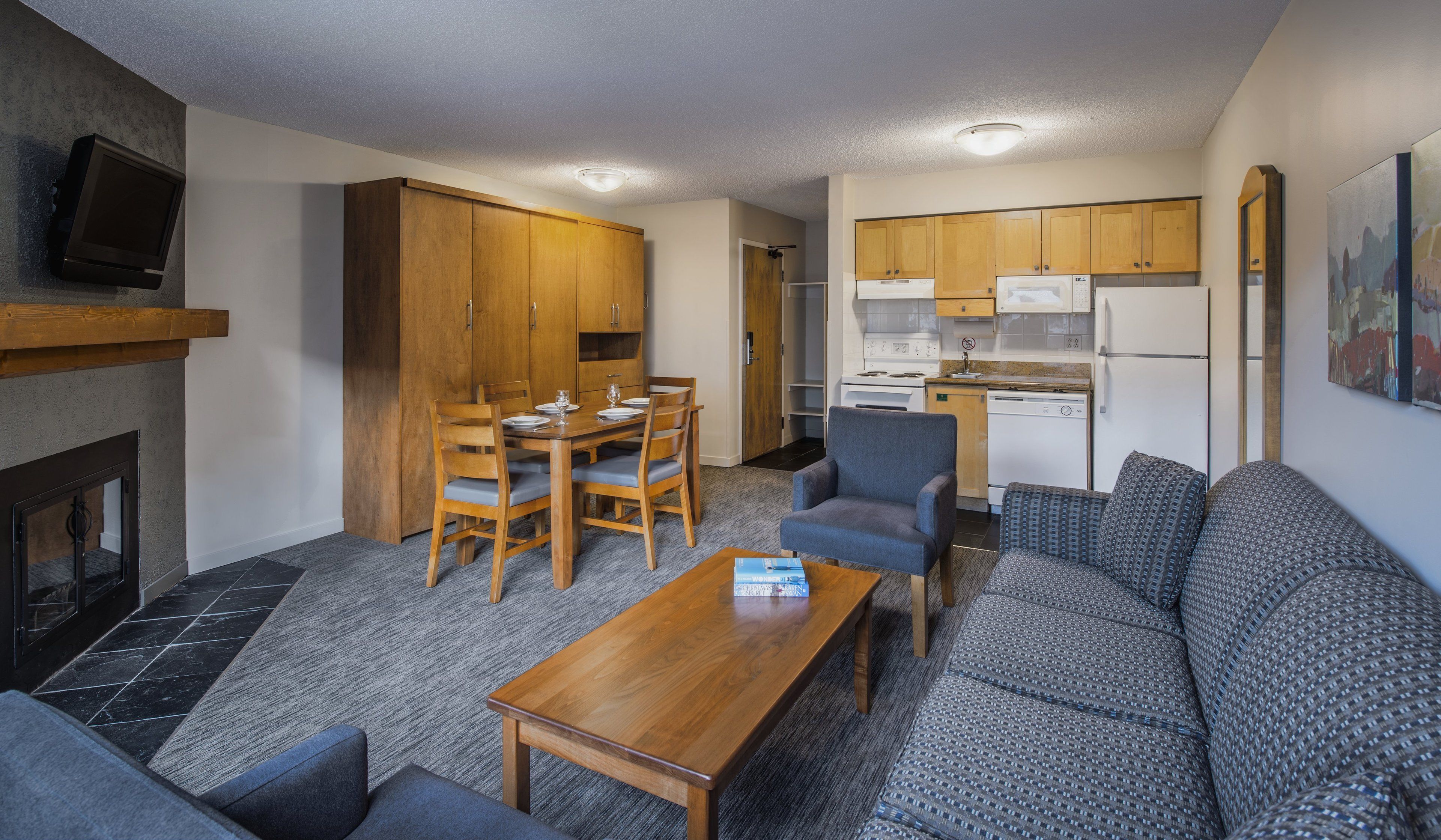 Un espacio habitable compacto con comedor, sofá y kitchenette.