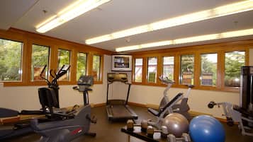 A gym with treadmills, elliptical machines, and free weights.