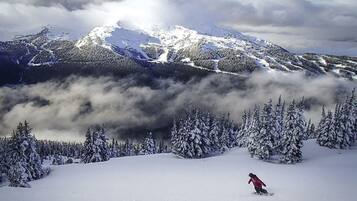 A snowy mountain landscape with a person snowboarding.