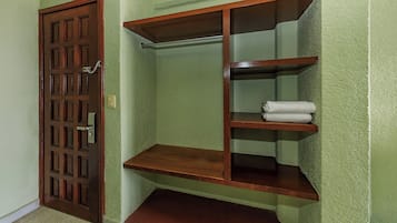A room with a wooden door, a built-in shelf unit, and a carpeted floor.
