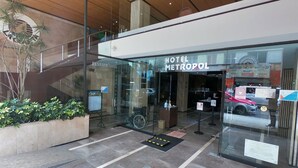 A hotel entrance with a modern design, including a glass facade, a staircase, and a sign for 'HOTEL METROPOL'. - Hotel Metropol (Mexico City)