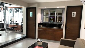 A gym with exercise equipment, a mirror, and a small table with a magazine. - Hotel Metropol (Mexico City)