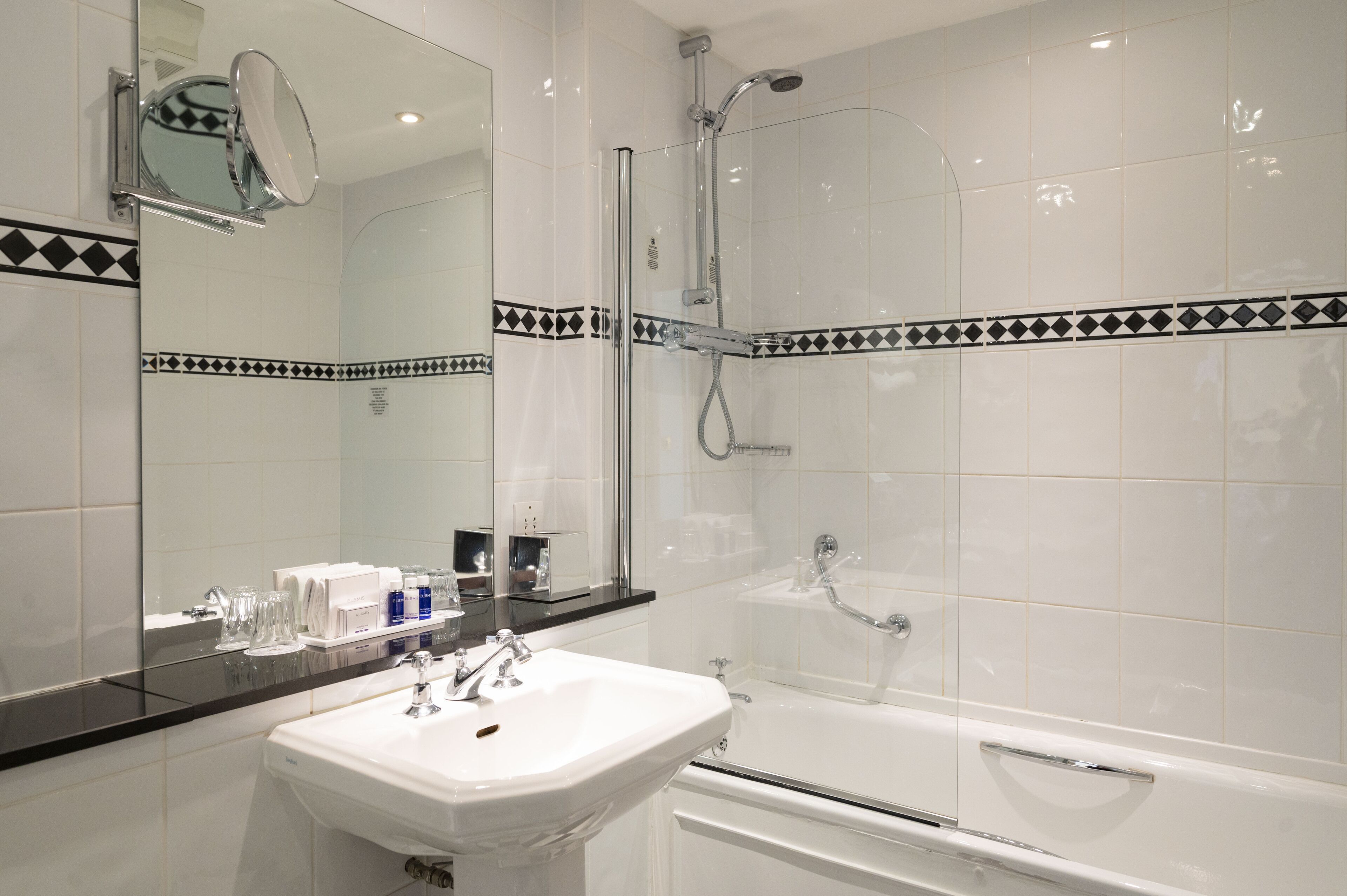 Une salle de bain moderne avec un lavabo blanc, une douche en verre et une baignoire.