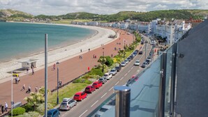 A coastal road with a beach on one side and buildings on the other. - St George's Hotel (Llandudno)