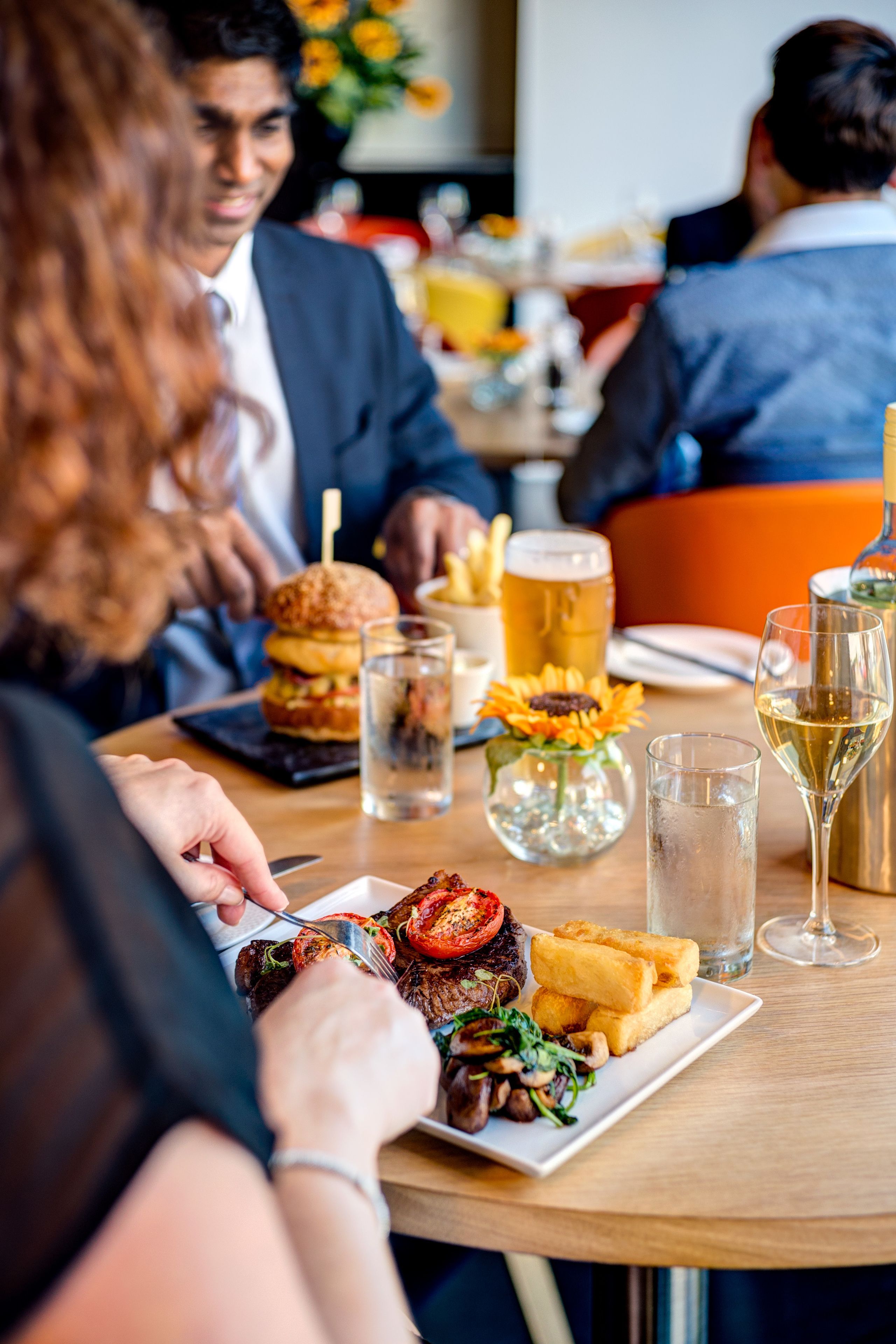 A dining table with food, drinks, and a beer mug.