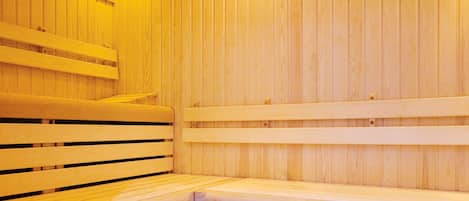 Un sauna en bois avec des bancs et un banc muni d’une serviette.