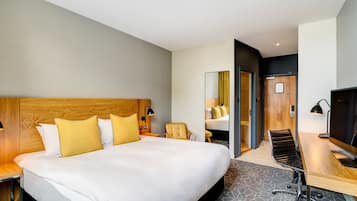Een moderne hotelkamer met een groot bed, een bureau, een stoel en een televisie.
